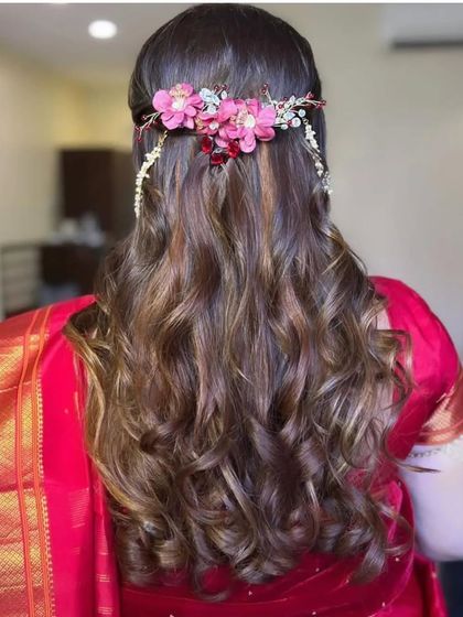 A full view of the floral hair accessory on a bed of soft curls, a perfect fusion of traditional and contemporary styling.