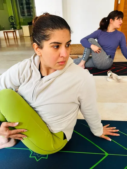 The focus and determination in our students is inspiring. Here, a student moves into Ardha Matsyendrasana (Half Lord of the Fishes Pose), a deep spinal twist that improves digestion and flexibility.