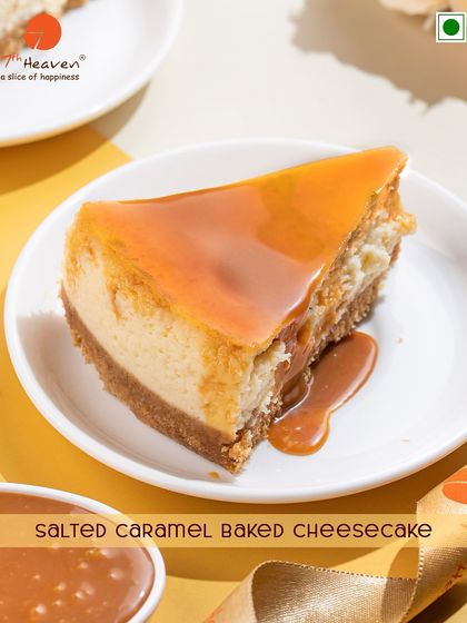 A perfect slice of our Salted Caramel Baked Cheesecake. This dessert features a rich, creamy baked cheesecake with a generous layer of gooey salted caramel on top.
