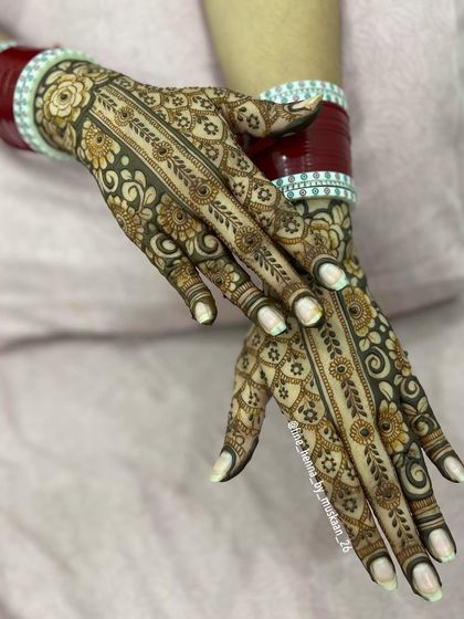 The matching back-of-hand design for the 'chura vadhai' ceremony, featuring a beautiful floral vine.