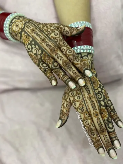 The matching back-of-hand design for the 'chura vadhai' ceremony, featuring a beautiful floral vine.