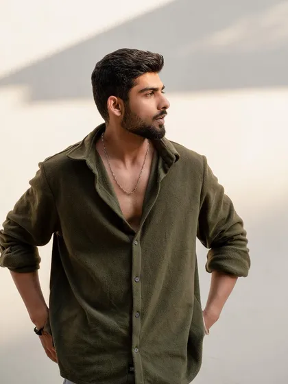 A profile shot of a model in an olive shirt, looking away from the camera. This adds a sense of story and is great for lifestyle or editorial sections of a portfolio.