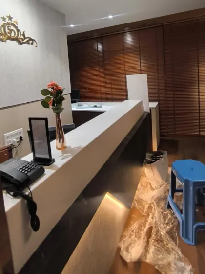 Here, I installed dark wooden Venetian blinds behind a reception desk to create a sophisticated and professional backdrop. They are highly functional for reducing screen glare and maintaining a comfortable environment.