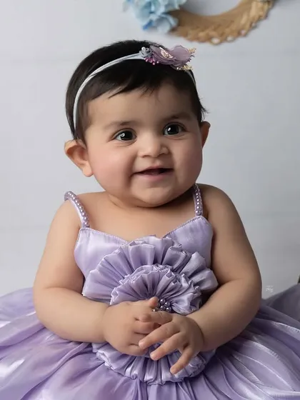 A bright, happy smile from this little star. This close-up captures her joyful personality and the beautiful details of her lavender dress.