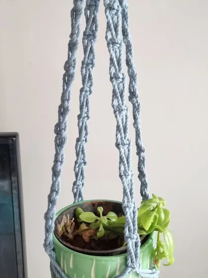 A dusty blue plant hanger, offering a cool and serene look. It pairs beautifully with a variety of pots and plants.