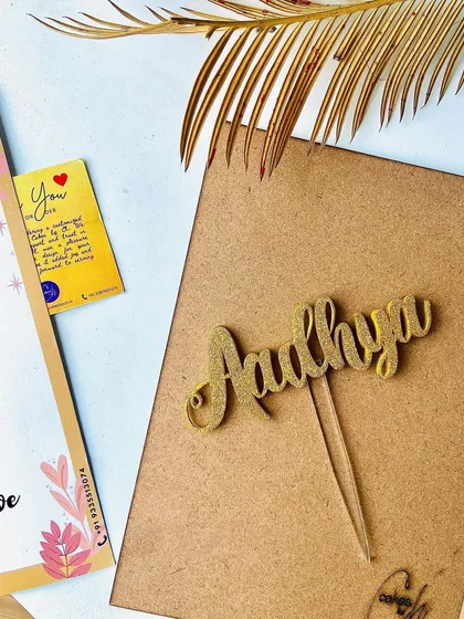 Add some sparkle with our glitter finish! This "Aadhya" name topper in gold glitter is perfect for adding a fun and festive touch to any cake.