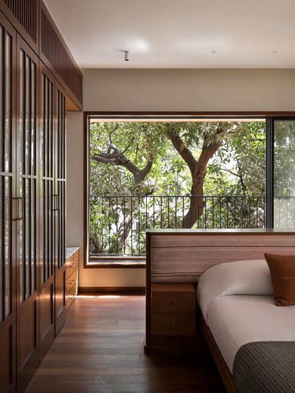 The master bedroom, where the custom low-profile bed is positioned to perfectly frame the view of the trees outside. I design bedrooms to be a seamless connection between the indoor sanctuary and the outdoor world.