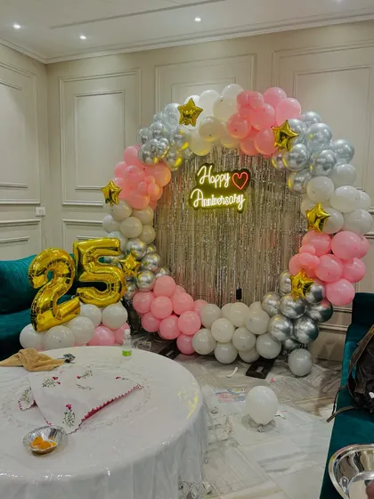 The full view of the 25th-anniversary ring backdrop with large foil numbers.