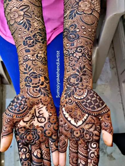 Another view of this stunning floral bridal mehendi. The name 'Aqib' is written in elegant Arabic script, nestled among the flowers on the palm.