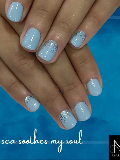 A calming, sea-inspired manicure. We used a soft powder blue polish and added a simple silver glitter fade on the accent nails for a serene and pretty look.