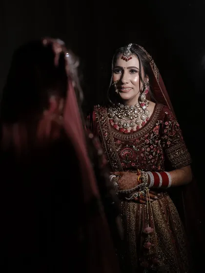 A beautiful portrait capturing the bride's reflection. The lighting highlights her flawless skin and the intricate details of her makeup.