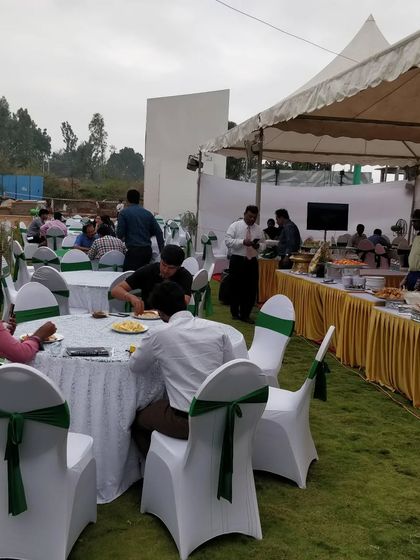 A wide shot of an outdoor event we catered, showing the dining area and buffet line. We are experienced in managing logistics for large-scale outdoor gatherings.
