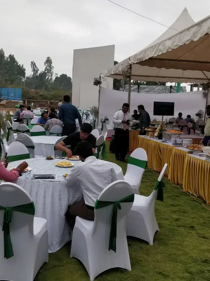 A wide shot of an outdoor event we catered, showing the dining area and buffet line. We are experienced in managing logistics for large-scale outdoor gatherings.