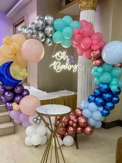A colorful 'Oh Baby' balloon ring. This vibrant mix of pastel and metallic balloons with a blue moon accent is perfect for a modern and fun baby shower.
