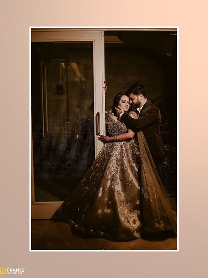 A romantic photo of a couple, with the groom in a dark, elegant three-piece suit that complements the bride's gown perfectly.