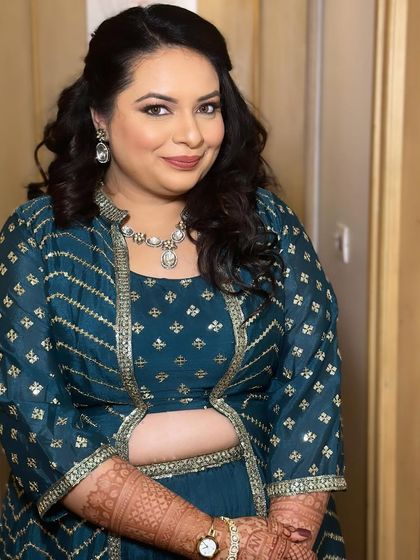 A close-up portrait showing her beautiful smile and the elegant makeup.