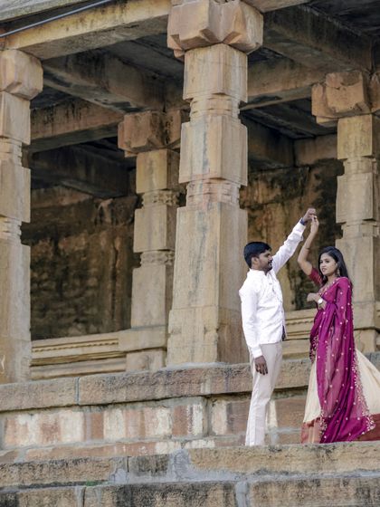 A playful moment during a pre-wedding dance at a historic temple site. It shows the couple's fun side against a grand backdrop.
