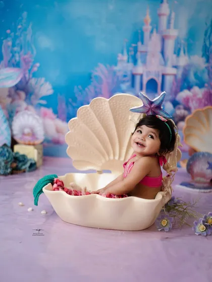 A joyful smile from our little mermaid, sitting happily in her seashell. These fantasy photoshoots are designed to be fun and engaging for your child.