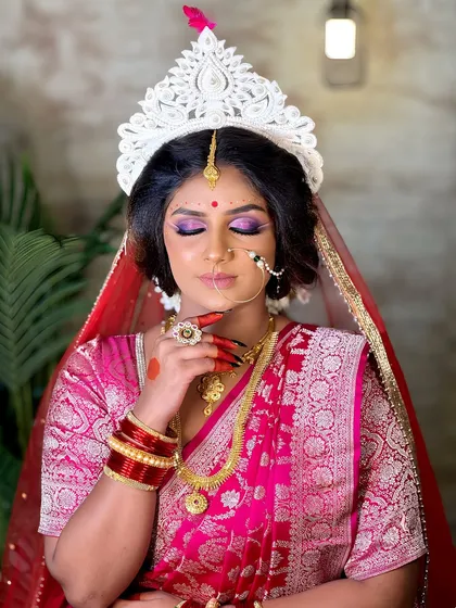 A full view of the Bengali bride, showcasing the rich pink Banarasi saree and gold jewelry. This is a look my students learn to create during our course.