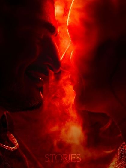 An abstract and artistic fine art portrait using the element of fire to represent passion. The couple's silhouettes are illuminated by a fiery red glow, creating a powerful and dramatic image of their love.