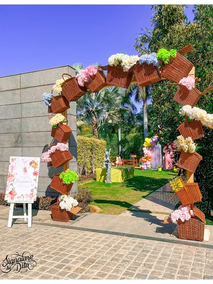 The entrance to the secret garden was this beautiful arch made of wicker baskets filled with flowers. It's a unique and rustic take on a classic party entrance, setting a whimsical tone from the very first step.