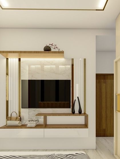 This view of the bedroom shows the TV unit, which matches the room's elegant theme with white, wood, and gold accents, creating a cohesive and sophisticated space.