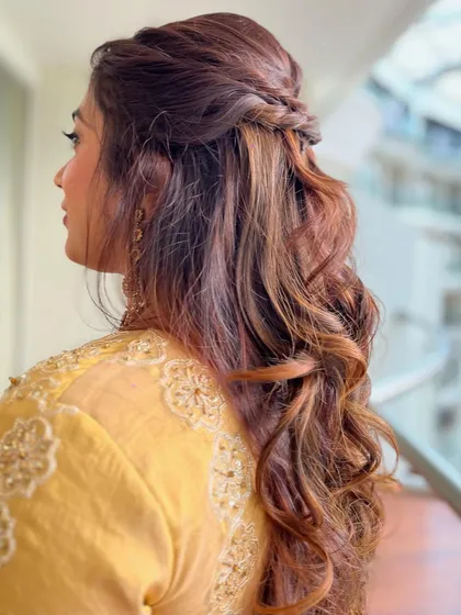 A gorgeous half-updo with twisted braids and textured curls, perfect for hair with highlights.
