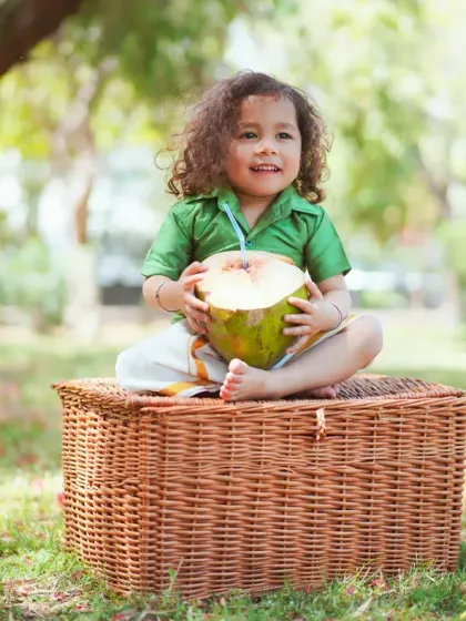 A happy smile from this little one during his outdoor photoshoot. The lush green background makes the colors of his outfit pop.