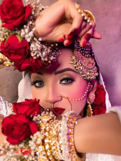 Peeking through the flowers, this shot captures the captivating eyes and flawless makeup of our Nikkah bride.