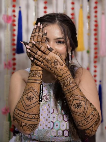 A playful pose from a bride, giving a full view of her matching arm designs, which feature large, striking lotus flowers.