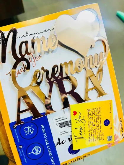 A "Name Ceremony Ayra" topper, designed to celebrate the beautiful tradition of a baby's naming day.