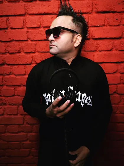A stylish shot from a recent photoshoot against a red brick background. My look is modern and edgy, just like the music I spin.
