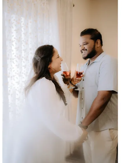 A happy toast with wine by a window, captured with soft, bright light for a celebratory and romantic feel.