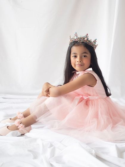 Every girl deserves to feel like a princess on her birthday. This portrait captures her regal pose in a crown and elegant pink dress.