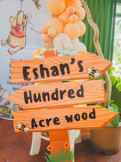 A charming wooden signpost pointing the way to "Eshan's Hundred Acre Wood."