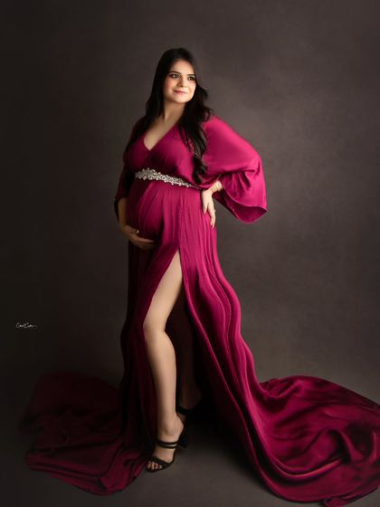 A confident and glamorous pose in a magenta satin gown, showing off the beautiful train and thigh-high slit.