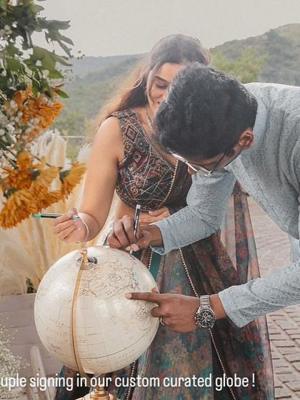 For a destination wedding, we love incorporating unique guest activities. Here, the couple signs a custom-curated globe, creating a beautiful keepsake of their journey and the places they'll go together.