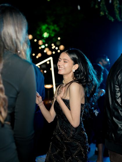 The bride smiling and dancing, her modern, fitted dress allowing her to move freely and enjoy the party.