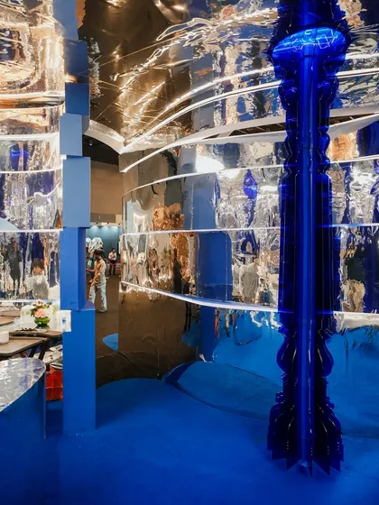 The 'Mercury' installation was designed to be a sensory experience. The rippling chrome surfaces don't just reflect you, they distort and reimagine you, making you a part of the art. The glowing cobalt column stands as a beacon in this fluid, ever-changing environment.