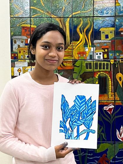 A student proudly holds up her two-color botanical print, created during our serigraphy workshop.