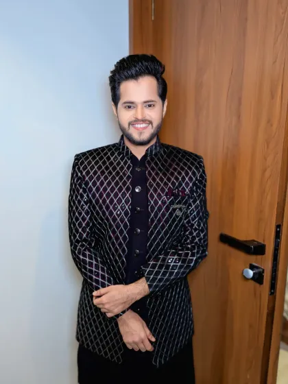 A full look at this modern groom's outfit. The combination of a textured jacket and clean grooming is a winning formula for any pre-wedding event.