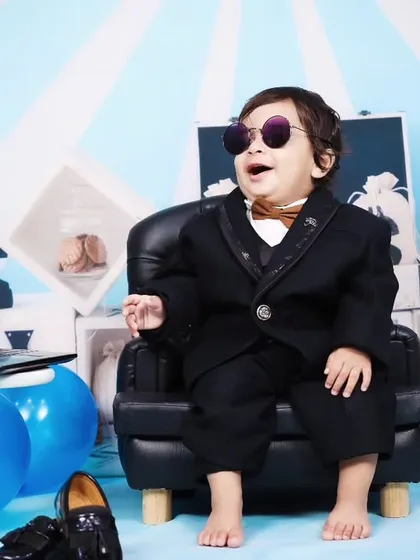This cool 'Boss Baby' is leaning back in his chair with sunglasses on, full of attitude.