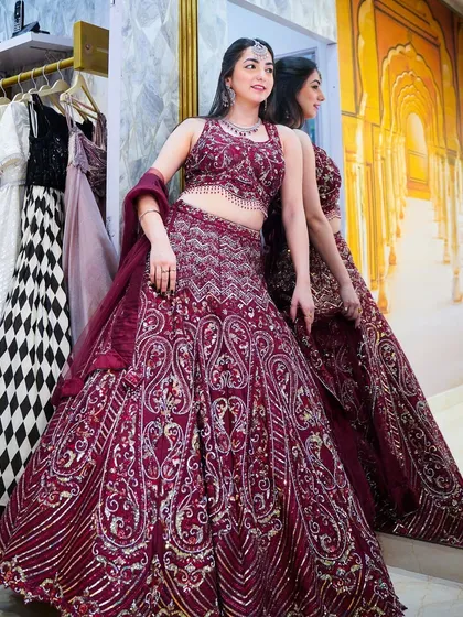 A full-length shot of a stunning maroon bridal lehenga. When I model for wedding couture, the goal is to showcase the intricate details and the overall grandeur of the outfit.