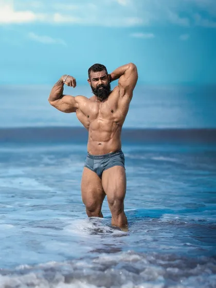 A physique is built in the gym but should be displayed with confidence anywhere. This classic pose on the beach showcases the kind of lean, muscular, and aesthetic body that is the goal of contest preparation. It's about achieving a look that is powerful and visually impressive.