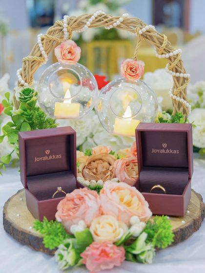 The ring platter is a small but significant detail. For this engagement, we created a rustic and romantic platter with a wooden base, flowers, and candles in glass orbs to display the rings beautifully.