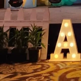 A close-up of a light-up marquee letter "A". These letters are a great way to add a personalized and decorative element to any party space.