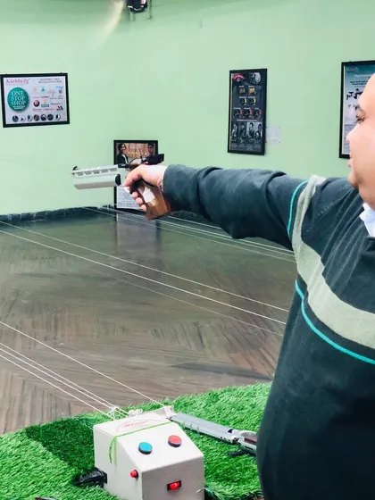 A student practices his air pistol shooting technique. Our coaches work with each individual to correct form and improve accuracy.