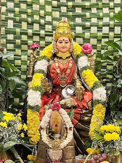 A close-up of the Goddess, her divine grace enhanced by the rich texture and color of the handwoven silk saree.