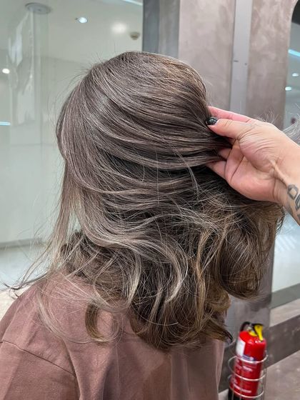 A close-up on a beautiful ash hair color, showing the blend of cool tones and the healthy texture of the hair.