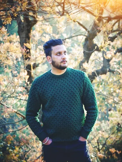 A simple, natural light portrait session for an individual portfolio. The focus is on a relaxed, confident expression, using the soft afternoon sun and natural foliage to create a warm, approachable look.